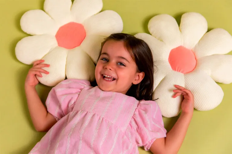 Niña tumbada con almohadas en forma de girasoles pv26